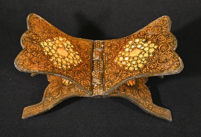 une boîte en bois richement décorée, avec des motifs dorés sur fond noir