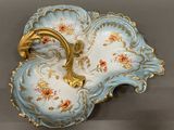 a blue and gold plate with a flower design on it