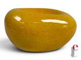 a large yellow bowl sitting on a white surface