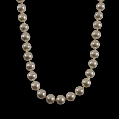un collier de perles blanches sur fond noir