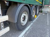 a green semi truck parked in a parking lot