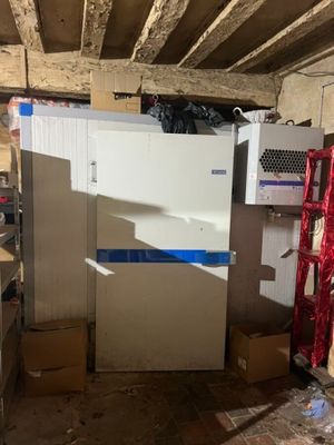 un réfrigérateur au milieu d'une pièce, avec des cartons par terre