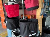 many bags that are hanging on a pole in a garage