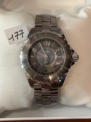 La montre se trouve dans la boîte posée sur la table, à côté de l'oreiller.