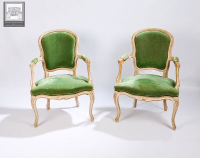 paire de fauteuils en velours vert avec des accoudoirs en bois sculpté