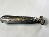 a silver spoon that is on a white surface
