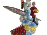 a figurine of a man and a woman riding on a rocket