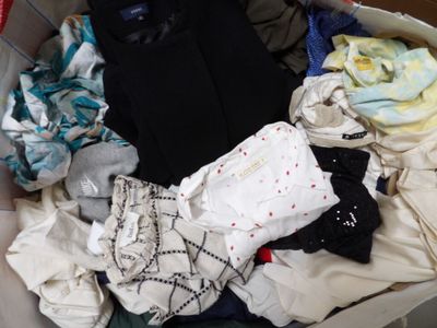 a suitcase full of clothes and clothes sitting on the floor