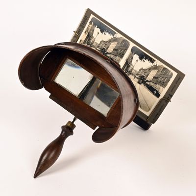 un petit miroir muni d'un manche en bois et orné d'une illustration