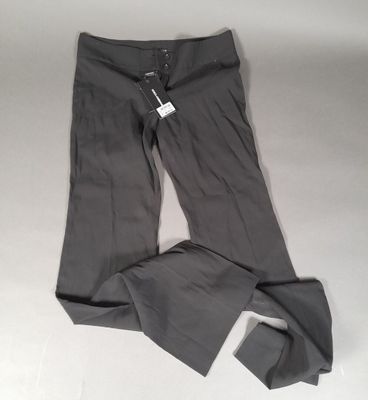 Le pantalon est gris et comporte une étiquette blanche.