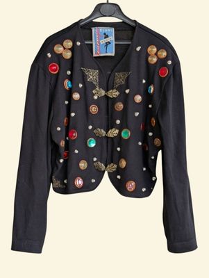 black jacket with buttons and buttons on it hanging on a hanger