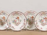 six assiettes ornées de motifs floraux sont alignées sur une table