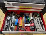 someone is holding a tool box full of tools on the floor
