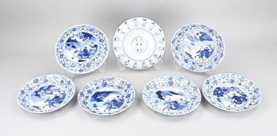 six blue and white plates and a bowl on a white surface