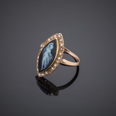 a gold ring with an image of a woman and pearls