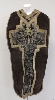 un gilet marron orné d'une croix, posé sur un support de mannequin