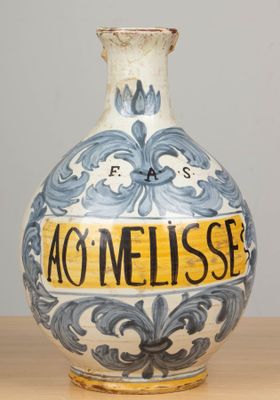 un vase bleu et blanc sur lequel est collée une étiquette jaune