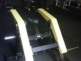 des appareils de musculation jaunes et noirs dans une salle de sport au sol noir