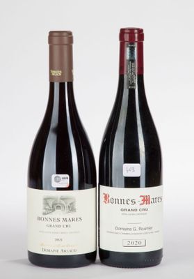 deux bouteilles de vin posées l'une à côté de l'autre sur une surface blanche