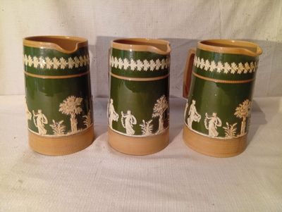 trois vases verts et blancs ornés de motifs, posés sur une table