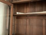 a wooden cabinet with a glass door in a room