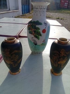 three vases sitting on a table outside on a sunny day