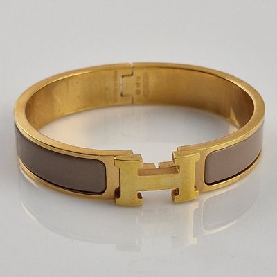 bracelet orné d'incrustations d'émail doré et marron sur un fond blanc