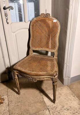 une chaise en osier posée devant une porte