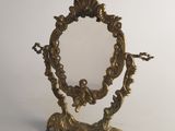 miroir en laiton plaqué, sur pied, avec un motif orné sur le dessus