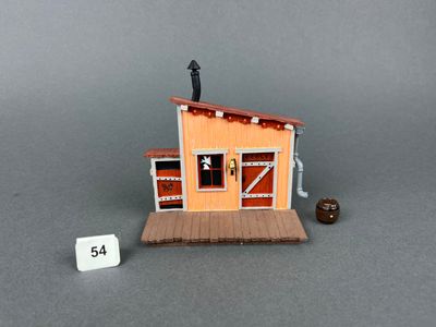 a small wooden building with a sign next to it