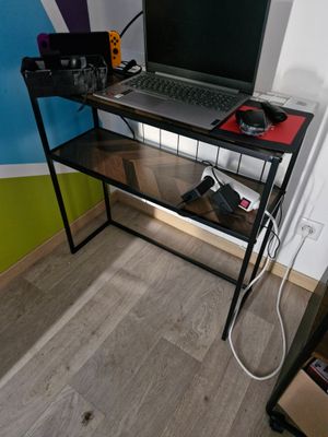 a laptop computer sitting on top of a glass desk