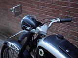 a black and silver motorcycle parked next to a brick wall