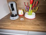 a coffee maker on the counter next to a vase of flowers