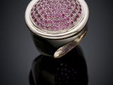 a close up of a ring with purple stones on a black surface