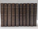 six vieux livres sont alignés sur une surface blanche