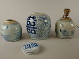 three blue and white vases and a lamp on a table