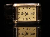 an image of a close up of a wrist watch on a black surface