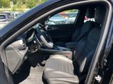 the interior of a car with the door open and the driver ' s seat up