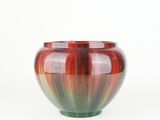 a close up of a red and green vase on a white background