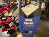 une nettoyeuse haute pression bleue et grise posée sur le sol d'un garage