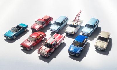 plusieurs petites voitures sont alignées sur une surface blanche