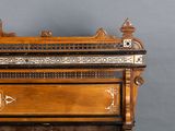 a wooden piano with a decorative design on the top