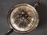 an antique silver plate with a flower design on it