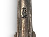 a silver clock on a stand on a white surface