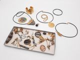 un plateau rempli de bijoux posé sur une table blanche
