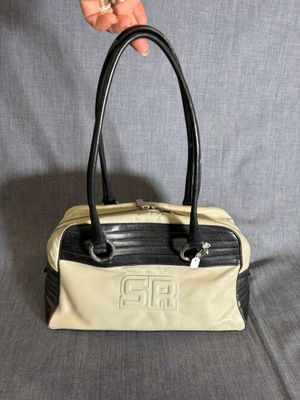 Quelqu'un tient un sac à main posé sur un canapé