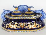 a blue and gold box with two fish and a shell on it