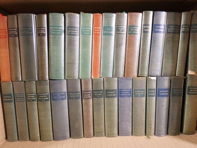 a lot of books that are stacked up on a shelf