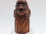 an old wooden figurine of a man with a hat and a cane