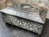 une boîte en argent posée sur une table en bois